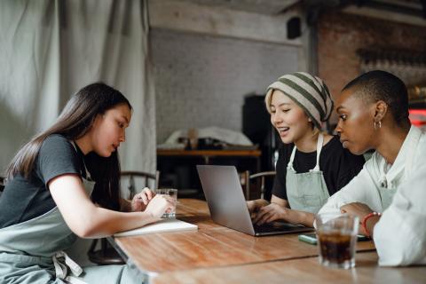 people doing stuff at a table in a coffee shop